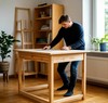 Мужчина собирает деревянный письменный стол в стиле ИКЕА в квартире
