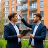 Покупатели квартиры стоят около многоэтажного дома с планшетом в руках