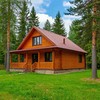Дом из бруса на фоне сосен летом