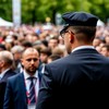 Сотрудник службы безопасности в костюме следит за ситуацией на многолюдном мероприятии