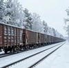 По заснеженной тайге по железной дороге идет длинный грузовой состав