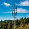 Мачта радиопередачи с тросами-растяжками на холме в лесу