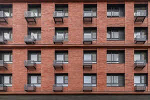 Фасад новостройки с установленными на нем корзинами для кондиционеров