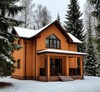 Двухэтажный кирпичный коттедж зимой на фоне хвойного леса